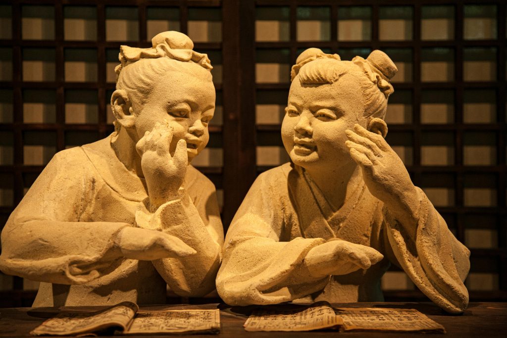 Insights Detailed stone sculptures of children reading in a peaceful indoor setting.