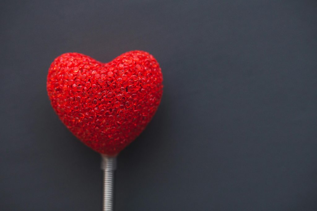 A vibrant red heart on a dark backdrop, symbolizing love and romance.